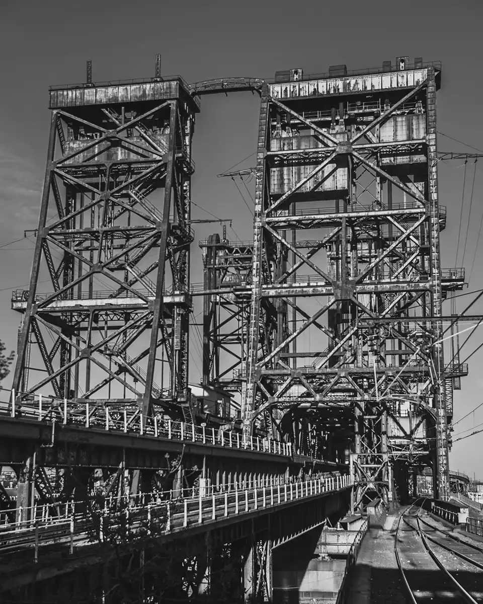 The Station - Black and white photo of a large train tower built over train tracks